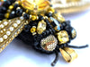 Close-up of a beaded bee with gold and black beads learn to bead