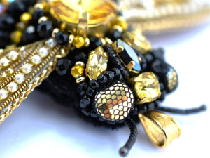 Close-up of a beaded bee with gold and black beads learn to bead