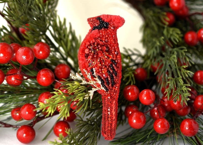 Red cardinal bird ornament on a green wreath with red berries